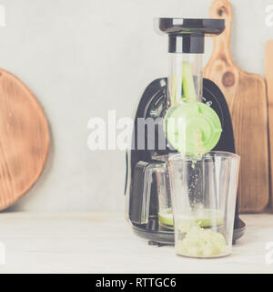 Langsam masticating Entsafter produzieren gesunde Sellerie Saft, am weißen Tisch , detox Konzept, selektiver Fokus Stockfoto