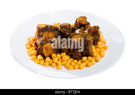 Geschmorte oxtails mit Kichererbsen auf einem weißen Teller. Auf weissem Hintergrund Stockfoto