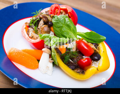 Frische Paprika gefüllt mit Pilzen, Reis mit Sesam, Kräutern und Gemüse Stockfoto