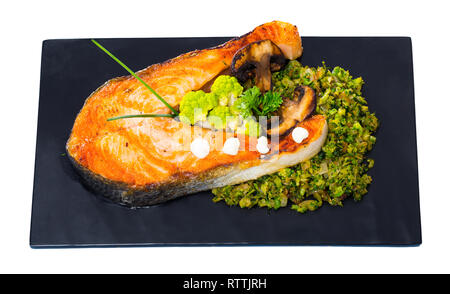 Leckeres Lachssteak mit Brokkoli und Gemüse auf schiefer serviert. Auf weissem Hintergrund Stockfoto