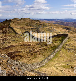 Lange gewundene, trockene Steinmauer nach den Ufern von Lingmoor Fell, Langdale, Lake District, Cumbria, England, UK Stockfoto