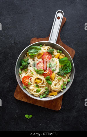 Pasta Primavera. Spaghetti Pasta mit Gemüse und Basilikum, Ansicht von oben, kopieren. Vegetarisch saisonale Pasta Primavera Rezept. Stockfoto