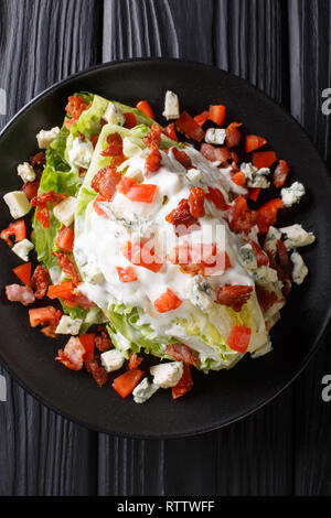 Keil Salat mit blauen Käse, Tomaten und Speck closeup auf einem Teller auf den Tisch. Vertikal oben Ansicht von oben Stockfoto