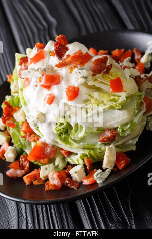 Amerikanische Keil Salat mit Eisbergsalat, Blue Cheese Dressing, knusprigen Speck und frischen Tomaten closeup auf einem Teller auf den Tisch. Vertikale Stockfoto