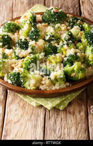 Brokkoli Salat mit Quinoa und Pinienkernen close-up auf einem Teller auf den Tisch. Vertikale Stockfoto