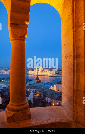 Ungarisches Parlament durch die Bögen von Fisherman's Bastion in der Dämmerung, Budapest, Ungarn gesehen. Stockfoto