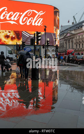 Piccadilly Circus, London, UK im Regen mit Reflexionen von Werbetafeln Stockfoto