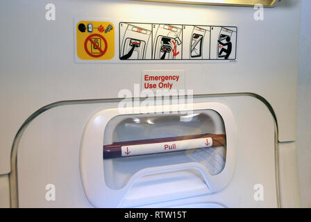 Notausgang mit Türgriff in einer Flugzeugkabine Stockfoto