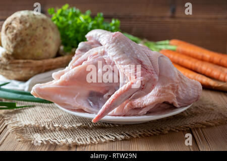 Zutaten für die Zubereitung von Knochen Brühe - frisches Hähnchenfleisch und Gemüse im Hintergrund Stockfoto
