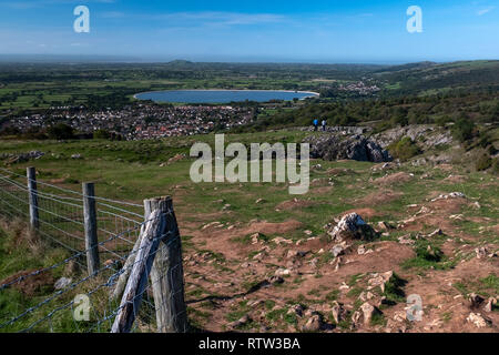 Der Blick von der Spitze des Cheddar Gorge in der gesamten Stadt von Cheddar suchen mit Reservoir und der Stadt in der Ferne mit einem strahlend blauen Himmel Stockfoto