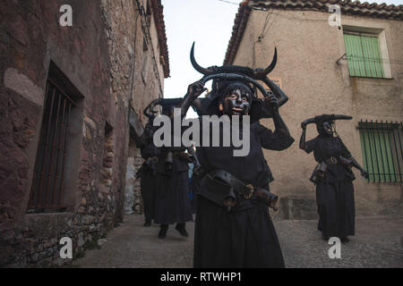 Luzon, Guadalajara, Spanien. 2 Mär, 2019. Nachtschwärmer sind Kleid mit Stier Hörner, Kuhglocken und Öl und Ruß während der Teufel von Luzon Karneval gesehen. Hunderte von Menschen aus der alten Tradition des Festivals der Teufel und die maskierten Figuren zu feiern. Leute kleiden wie Teufel mit Stier Hörner, Kuhglocken und Malen thei Körper mit schwarzen Öl und Ruß. Nachtschwärmer tragen weiße Masken. Die Tradition geht zurück bis in das 14. Jahrhundert. Credit: Bruno Thevenin/SOPA Images/ZUMA Draht/Alamy leben Nachrichten Stockfoto