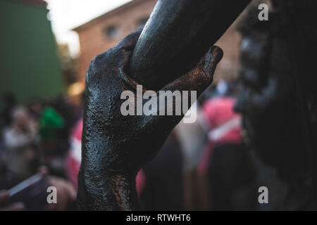 Ein näherer Blick auf einer Hand mit schwarzen Öl während der Teufel von Luzon Karneval abgedeckt. Hunderte von Menschen aus der alten Tradition des Festivals der Teufel und die maskierten Figuren zu feiern. Leute kleiden wie Teufel mit Stier Hörner, Kuhglocken und Malen thei Körper mit schwarzen Öl und Ruß. Nachtschwärmer tragen weiße Masken. Die Tradition geht zurück bis in das 14. Jahrhundert. Stockfoto