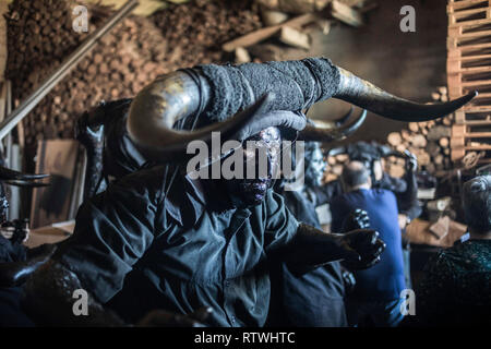 Ein Mann ist, kleiden sie sich wie ein Teufel während der Teufel von Luzon Karneval gesehen. Hunderte von Menschen aus der alten Tradition des Festivals der Teufel und die maskierten Figuren zu feiern. Leute kleiden wie Teufel mit Stier Hörner, Kuhglocken und Malen thei Körper mit schwarzen Öl und Ruß. Nachtschwärmer tragen weiße Masken. Die Tradition geht zurück bis in das 14. Jahrhundert. Stockfoto