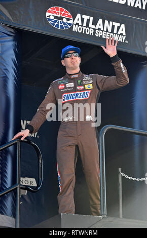 Hampton, GA, USA. 24 Feb, 2018. Snickers Toyota Fahrer Kyle Busch Wellen der Menge, die bei der Treiberinstallation Einführungen vor Beginn der QuikTrip Falten der Ehre 500 am Sonntag an der Atlanta Motor Speedway in Hampton, GA. Austin McAfee/CSM/Alamy leben Nachrichten Stockfoto