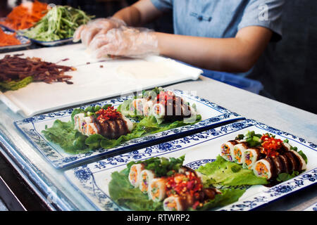 Frisch zubereitete chinesische Lebensmittel verkauft werden, auf der Straße, asiatische Lebensmittel kaltes Gericht, Brötchen mit Gemüse im Inneren. Stockfoto