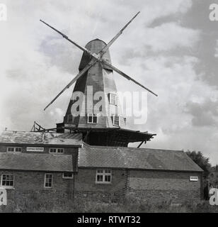 1970 s, historische Bild mit der Windmühle bei Roggen und äußeren Gebäude, die zu dieser Zeit beherbergte die Gopsall Töpferei, England, UK. Die weißen Kittel Mühle am Fluss Tillingham hat eines der berühmtesten Wahrzeichen der Stadt wurde seit Thomas Chatterton eine 'post Mill' im Jahre 1758 erbaut und vielleicht sogar, bevor dann, wie eine Karte von Roggen 1595 zeigt eine Abbildung einer Windmühle in die genaue Lage. Stockfoto