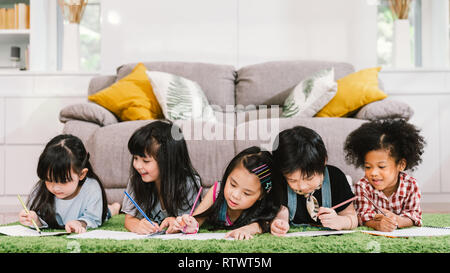 Gruppe von fünf multi-ethnischen Junge niedlich Vorschule Kinder, Junge und Mädchen glücklich zusammen studieren oder Zeichnung zu Hause oder in der Schule. Kinder Bildung Konzept Stockfoto