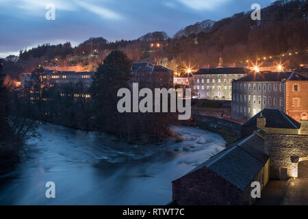 New Lanark Arbeit Weltkulturerbe in der Nacht übersicht Gebäude gesehen beleuchtet und Leuchten in Windows Stockfoto