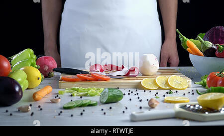 Der Mensch ist Schneiden von Gemüse in der Küche, Schneiden roten Rettich Stockfoto