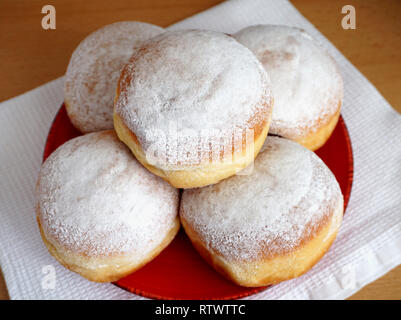 Hausgemachte leckere verzetteln Donuts aus sauerteig durch die alte Rezeptur auf der roten Platte, von oben. Stockfoto