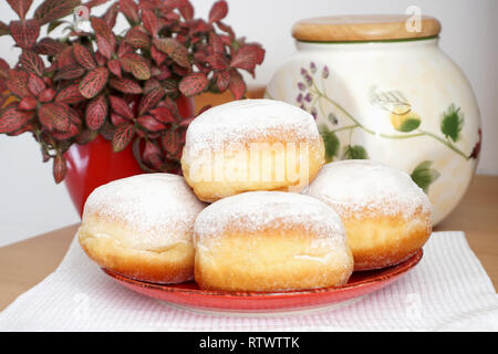 Traditionelle süße und leckere hausgemachte gebackene Donuts auf der Platte auf dem Küchentisch Stockfoto