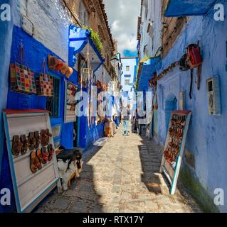 Verkauf von Leder Sandalen in schmale Gasse mit blauen Häuser, Medina von Meknes, Chaouen, Tangier-Tétouan, Marokko Stockfoto