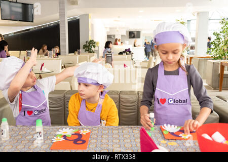 Kinder lernen kleine Kuchen mit Sahne zu kochen. Machen einen Urlaub Karte für Mama. März 8. Stockfoto