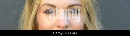 Close up 7/8 Portrait von eine attraktive blonde Frau mit blauen Augen und trug Make-up Stockfoto