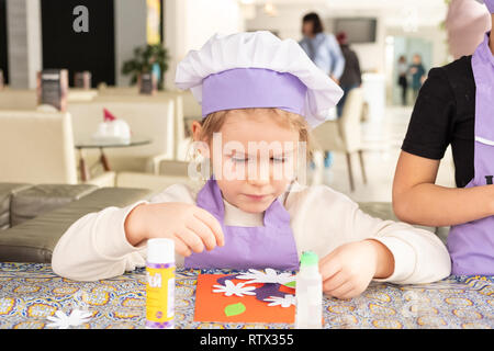 Kinder lernen kleine Kuchen mit Sahne zu kochen. Machen einen Urlaub Karte für Mama. März 8. Stockfoto