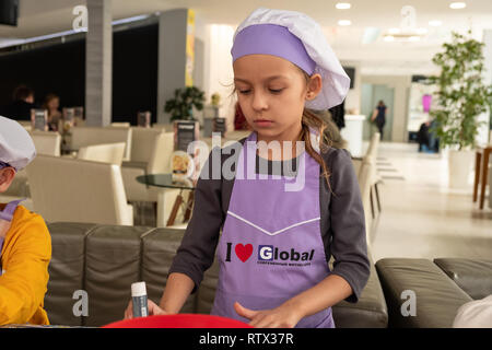 Kinder lernen kleine Kuchen mit Sahne zu kochen. Machen einen Urlaub Karte für Mama. März 8. Stockfoto