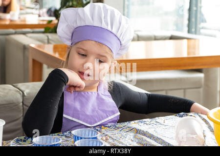 Kinder lernen kleine Kuchen mit Sahne zu kochen. Machen einen Urlaub Karte für Mama. März 8. Stockfoto