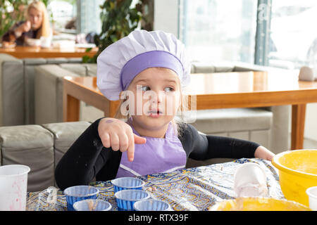 Kinder lernen kleine Kuchen mit Sahne zu kochen. Machen einen Urlaub Karte für Mama. März 8. Stockfoto