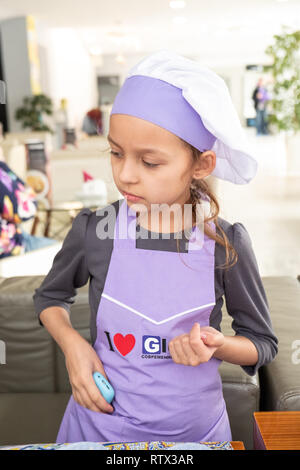 Kinder lernen kleine Kuchen mit Sahne zu kochen. Machen einen Urlaub Karte für Mama. März 8. Stockfoto