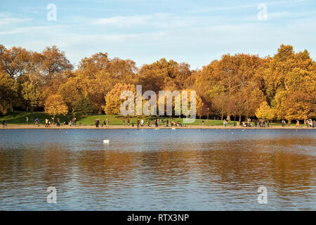 London, Großbritannien, 19. November 2006: Personen, die sonnigen Herbstnachmittag im Hyde Park, zu Fuß auf Bürgersteig in der Nähe der See Serpentine Lake. Stockfoto