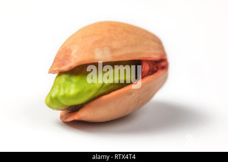 Einzelne rote Türkische Pistazie, Grüne Mutter unter Shell sichtbar, auf weißem Hintergrund. Stockfoto