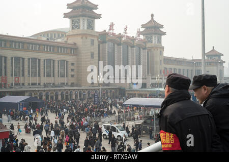 Zwei Männer beobachten Sie die Masse in der Beijing Railway Station. China verbietet 23 m vom Kauf von Fahrkarten als Teil des 'sozialen credit"-System 03-Mar-2019 Stockfoto