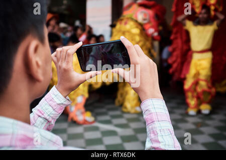 Dragon Tänzer Usher in das neue Jahr, indem Sie einen Tanz Ritual außerhalb der lokalen Unternehmen in der Feier des Chinesischen Neuen Jahres Stockfoto