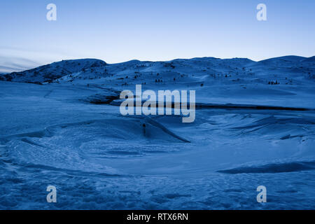 Winter Berglandschaft. Gefrorenen See mit Schnee und Eis auf der blauen Stunde abgedeckt. Stausee Belmeken in Winter, Bulgarien. Stockfoto