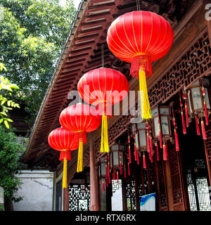 Helle rote Laternen mit gelben Quasten hängen vom Dach in den Yu Garten, das alte Shanghai, China. Stockfoto