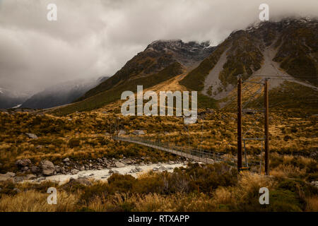 Ein Blick auf eine von drei Hängebrücken der Hooker Valley an einem bewölkten, Moody Tag. Das Tal ist im Mount Cook/Aoraki Nationalpark entfernt. Stockfoto