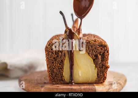 Schoko Birnen Kuchen auf einem Holzbrett, weisser Hintergrund. Obstkuchen mit Schokolade. Stockfoto