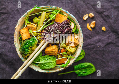 Asiatische vegan Pfannengerichte mit Tofu, Reis, Nudeln und Gemüse, Ansicht von oben. Stockfoto