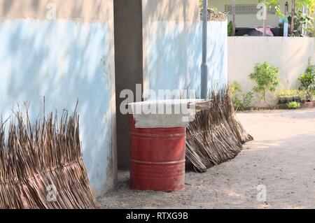 Red Oil Tank vor der Tür gestapelt und getrockneten Palmblättern (Ari Atoll, Malediven) Stockfoto