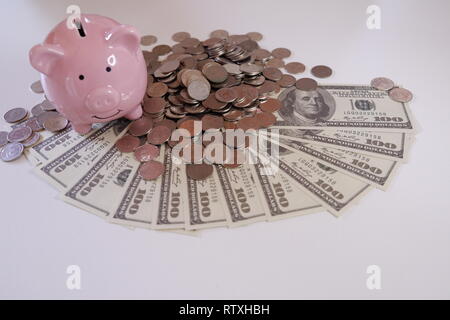 Nahaufnahme Sparschwein mit Münzen und Geld über den Schreibtisch Stockfoto
