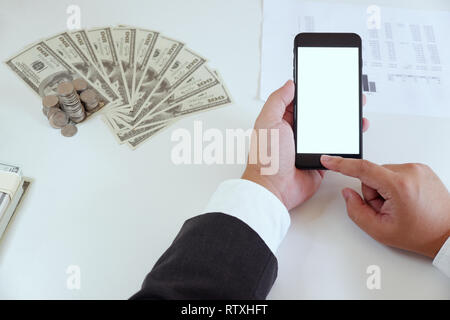 High-Winkel für die Verwendung im Büro Smartphone mit Geld auf Schreibtisch Mann Stockfoto