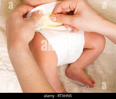 Windel wechseln auf ein neugeborenes Baby von Frau mit Maniküre Stockfoto