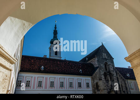 Innenhof und Blick auf die Zisterzienserabtei Stift Heiligenkreuz mit Dreifaltigkeitssäule Stockfoto