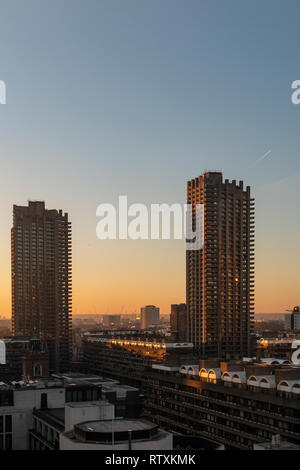 Die großen brutalist tower Blocks des Barbican Centre in London, da die Sonne untergeht Stockfoto