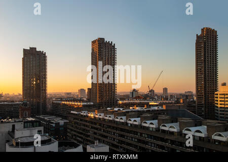 Die großen brutalist tower Blocks des Barbican Centre in London, da die Sonne untergeht Stockfoto