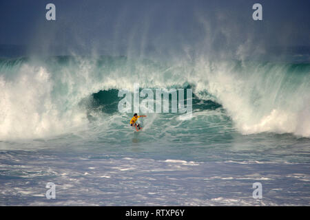 Surfer reitet eine große Welle, Waimea Bay, nördlich von Oahu, Hawaii, USA Stockfoto